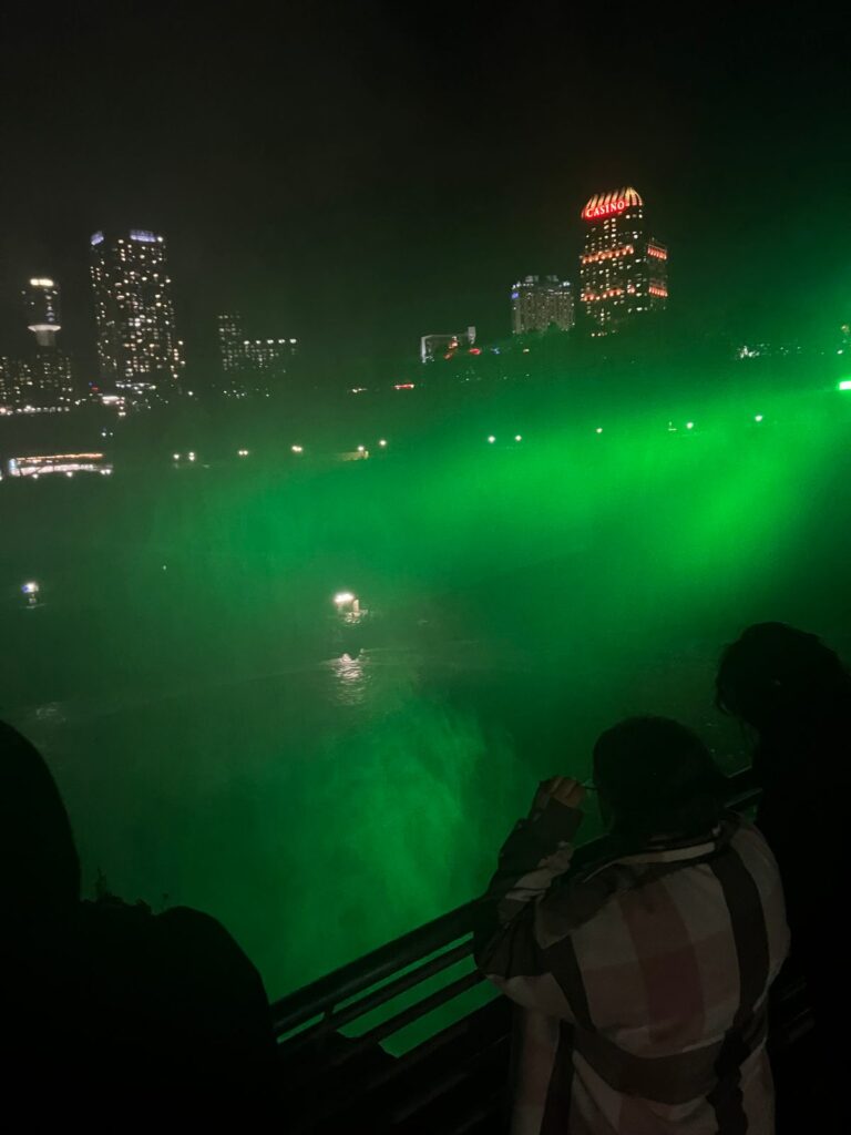 Niagara Falls lit green at night as onlookers watch, October 9, 2026