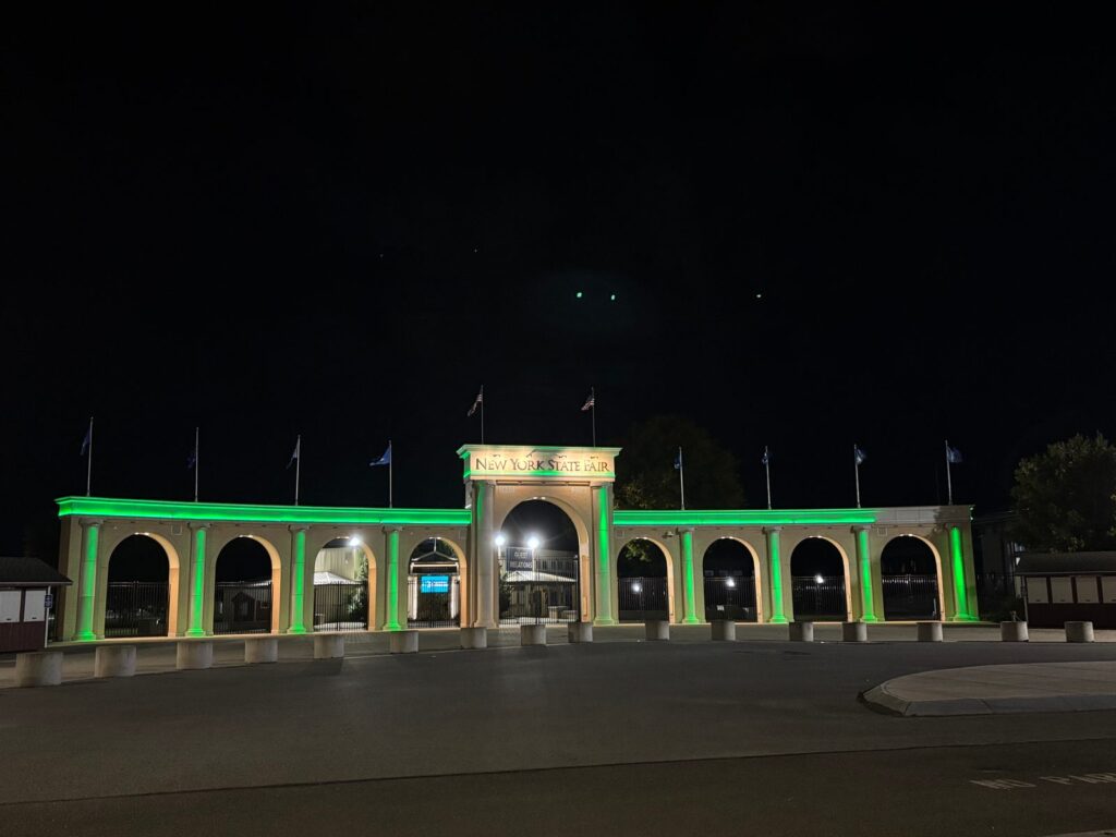 The New York State Fairgrounds Main Gate in Syracuse lit green, October 9, 2026